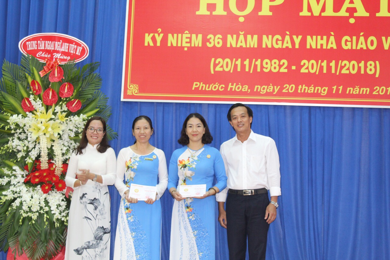 Thầy Trần Minh Tâm và bà Võ Thị Bích Thảo trao tặng huy hiệu “Vì sự nghiệp Giáo dục” cho 2 cô Hoàng Thị Hà và cô Hoàng Thị Hiền