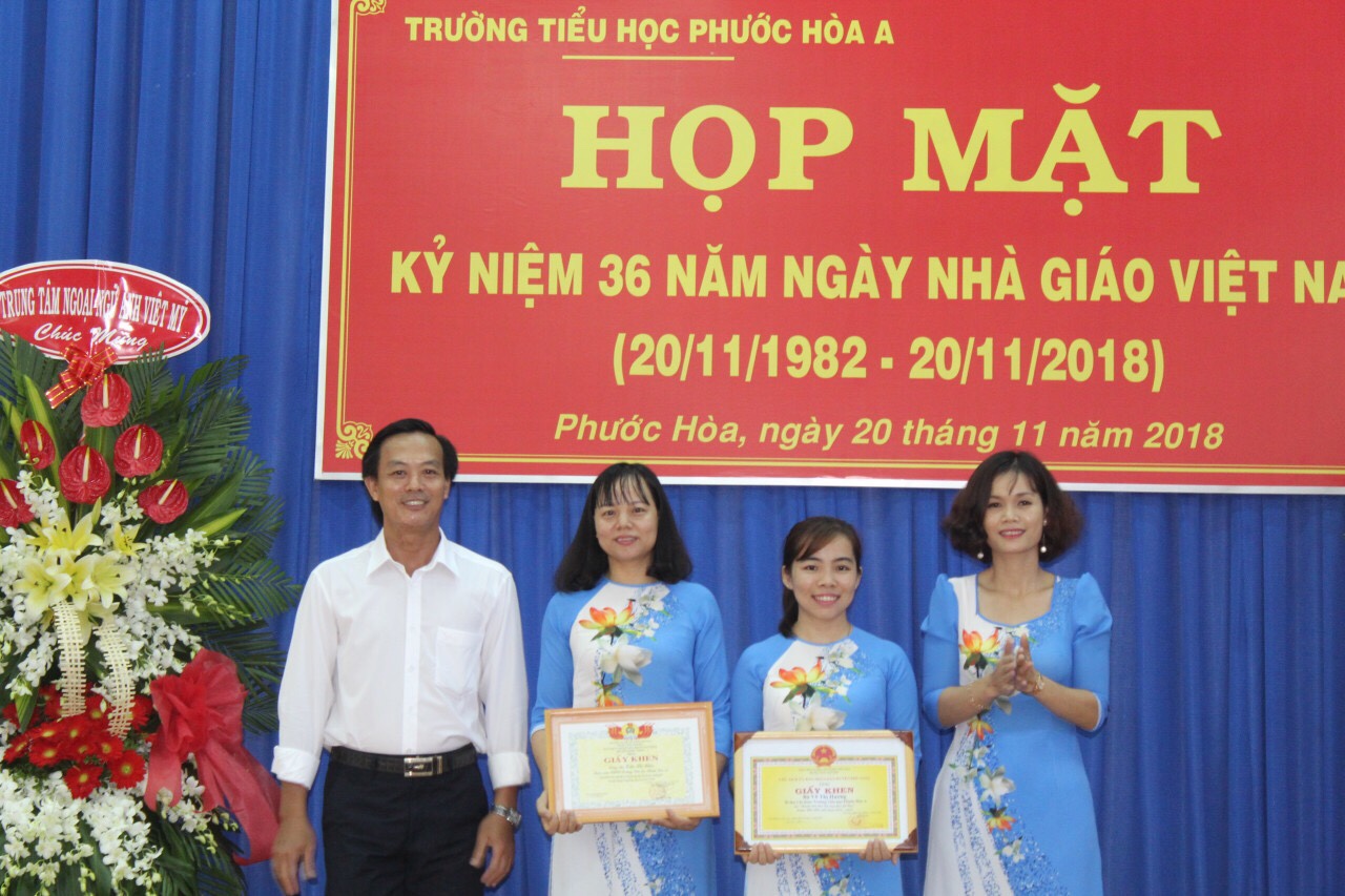 Thầy Trân Minh Tâm - Hiệu trưởng và cô Cao Thị Nghĩa - Phó hiệu trưởng trao giấy khen cho cô Trần Thị Hiền và cô Võ Thị Hương