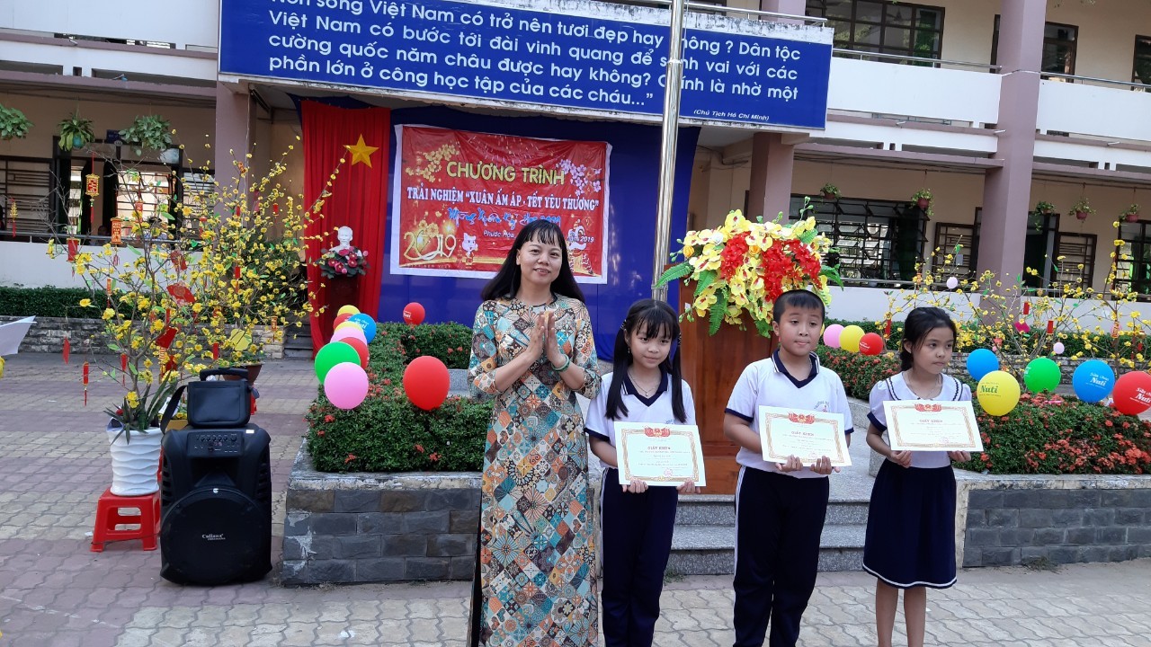 Cô Trần Thị Hiền - phó Hiệu trưởng trao giải phần thi trang trí cây mai đào cho HS lớp 3